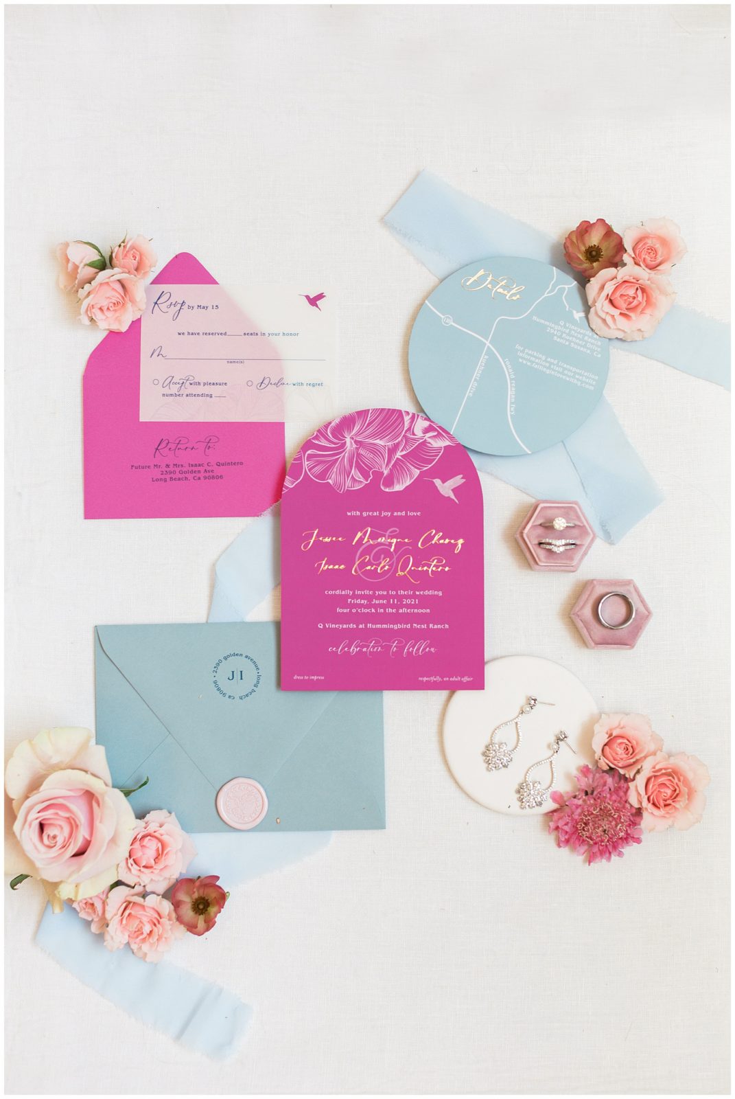 Bright pink and pale blue wedding invitation flatlay with jewelry