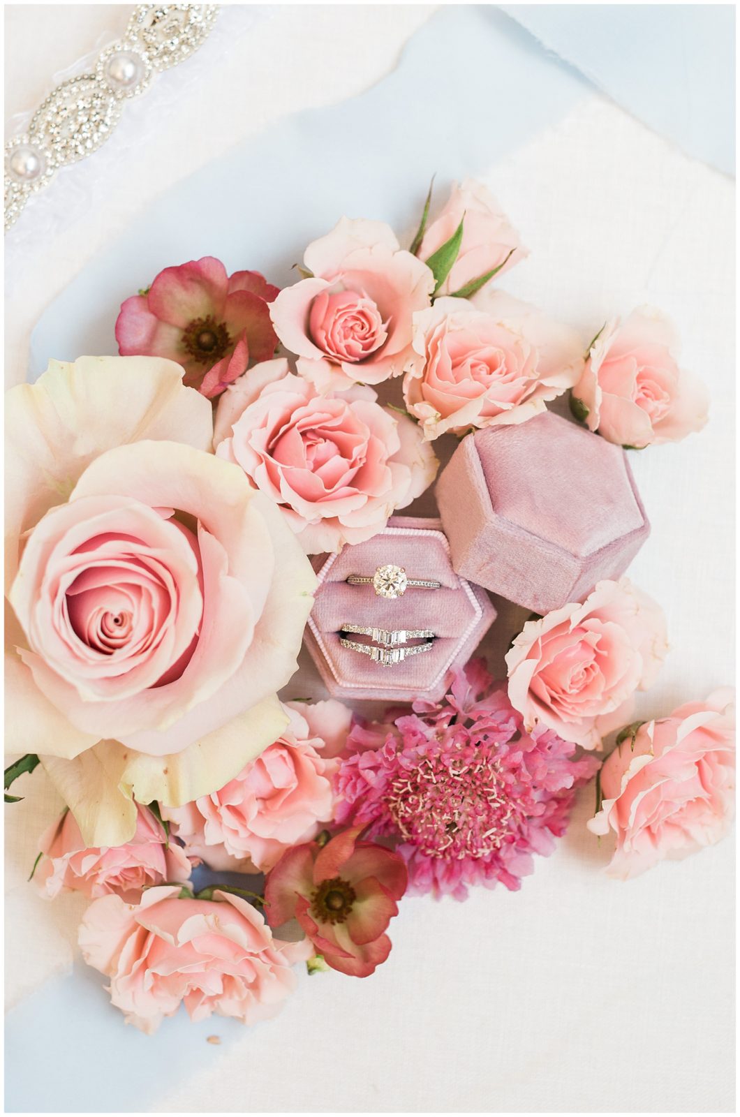 Wedding rings surrounded by pink roses and flowers