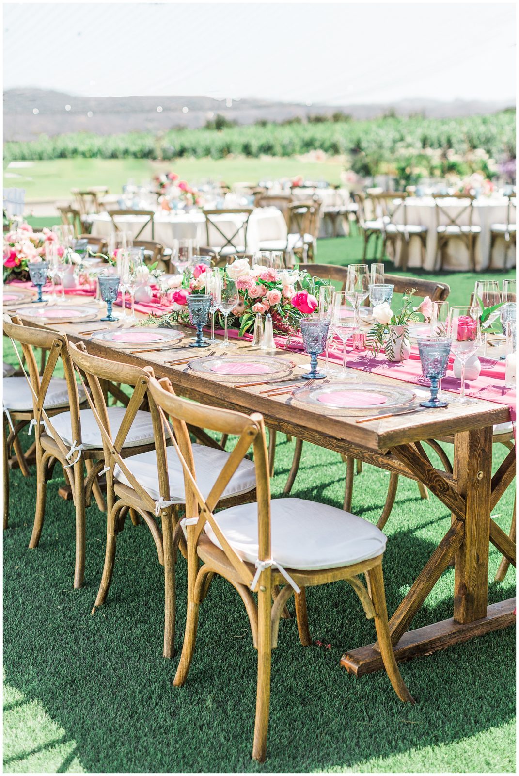 Farmhouse tables with pink runner and blue water glasses