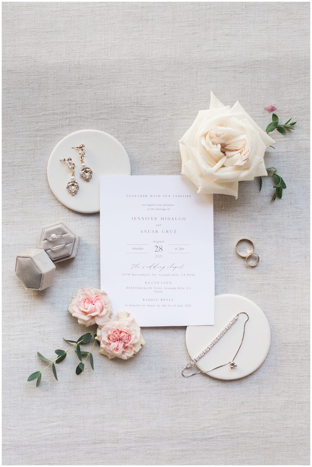 romantic backyard wedding flatlay detail shot with invitations and rings